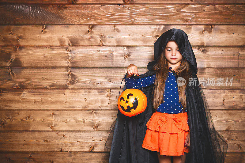 万圣节里穿着女巫服装的有趣的小女孩