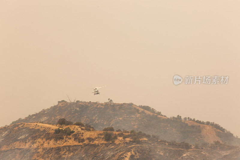 一架直升飞机在洛杉矶的金枪鱼森林大火上滴水
