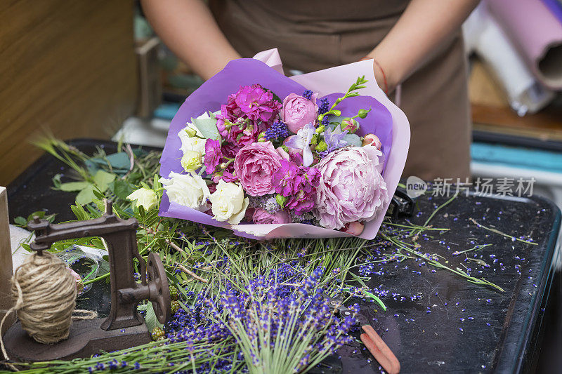 花店女性手的特写，打造时尚现代浪漫的不同鲜花的花束