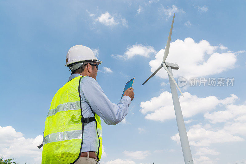 电气工程师使用数字无线平板设备与风力发电机