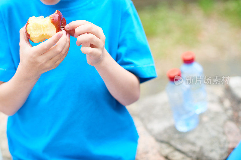 男孩在户外吃苹果