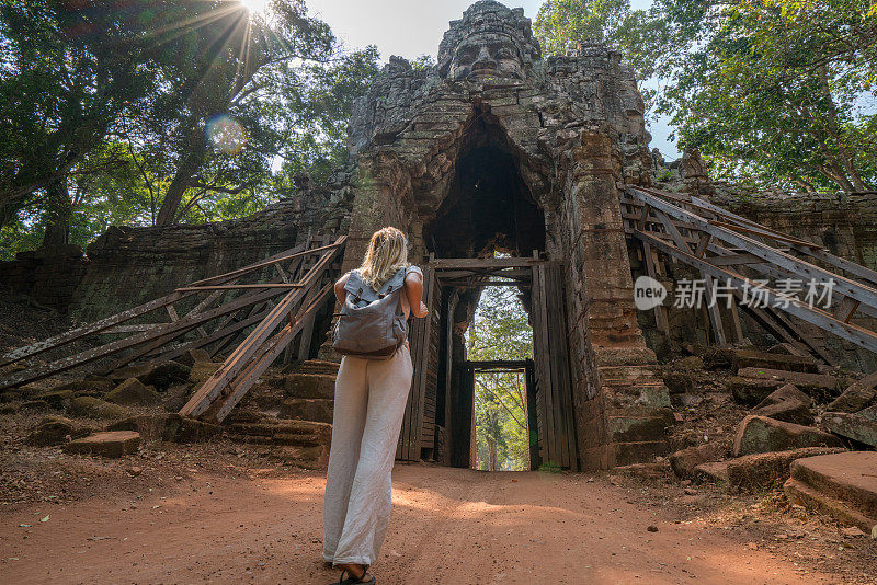 旅游女游客站在寺庙复杂的大门前仰望上面的雕塑，人们发现探索的概念