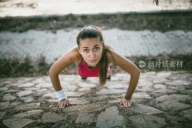 在大自然中做俯卧撑的女运动员