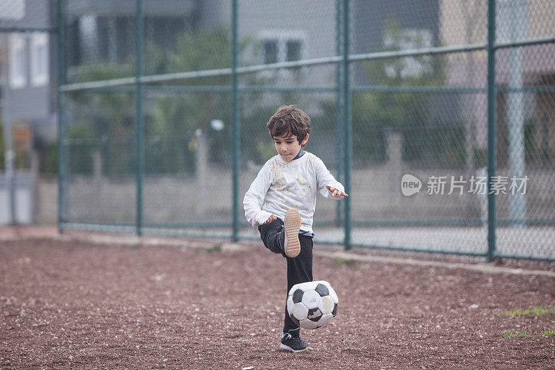 小男孩在户外踢足球