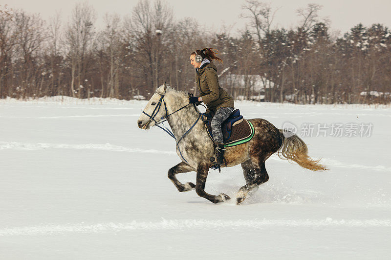 一个女人在雪地里骑马