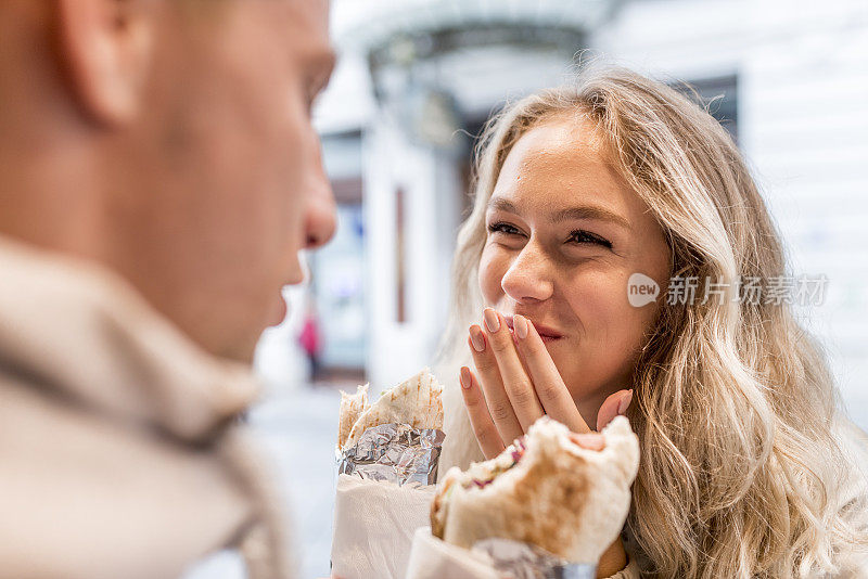 年轻夫妇在街头吃小吃