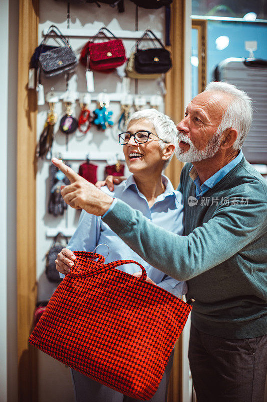 一对浪漫的老夫妇在假日期间在购物袋和饰品店寻找物美价廉的商品