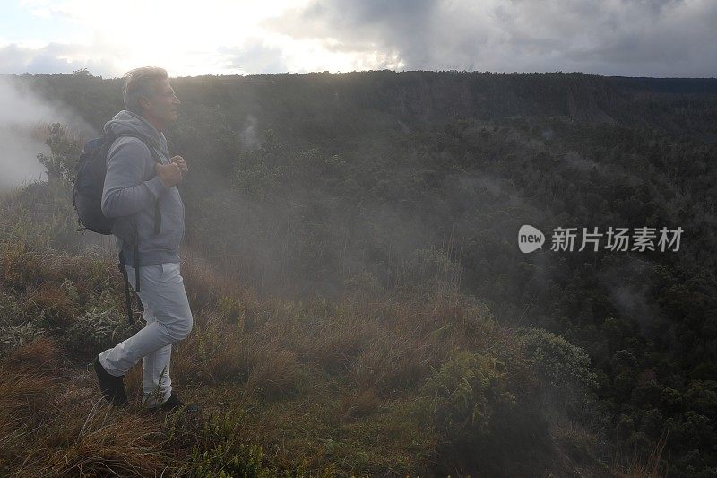 人们在雾中攀登火山边缘