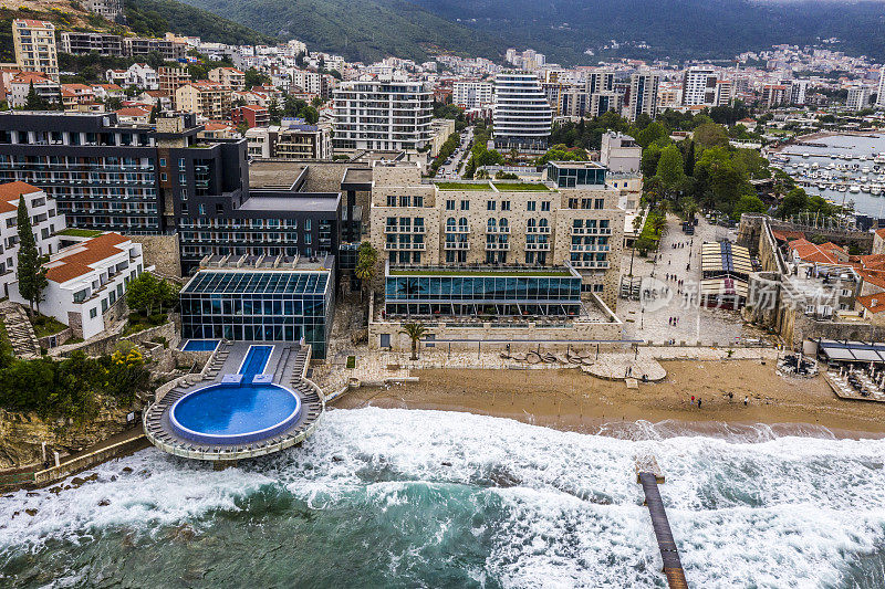 无人机视角下的一个旅游胜地与游泳池，延伸到海滩和亚得里亚海在Budva