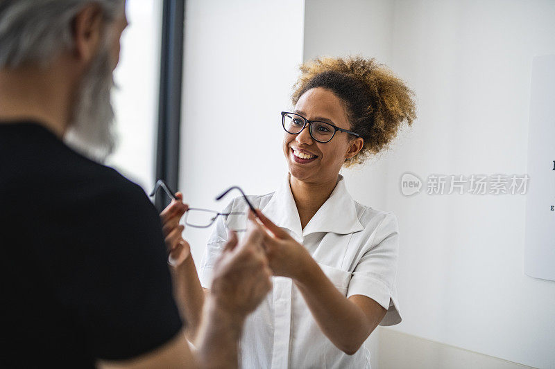 一个年轻女医生和她的客户谈论视力的肖像