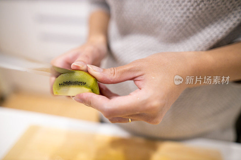 年轻女子在厨房剥猕猴桃