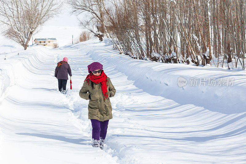 两个女人在雪地上朝相反的方向走