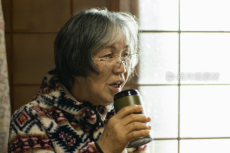 喝着奶瓶的日本老年妇女