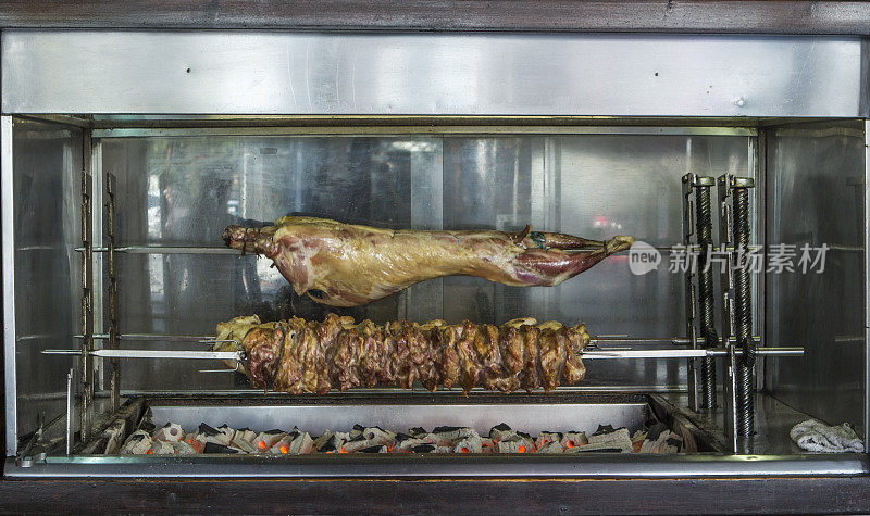 在希腊卡瓦拉岛萨索斯岛的帕纳吉亚村烹饪鸡肉、山羊和可可可可