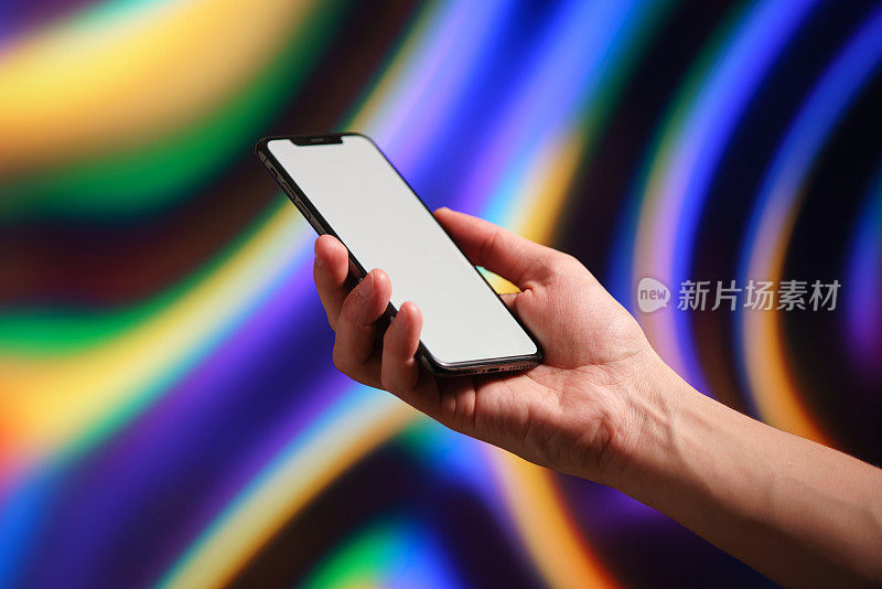 手机上有一个白色的屏幕，在一个男人的手中有一个充满活力的彩色液体背景，trand背景