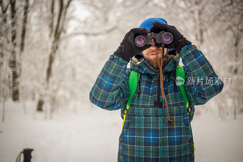 年轻英俊的男子在滑雪运动服山和看别处