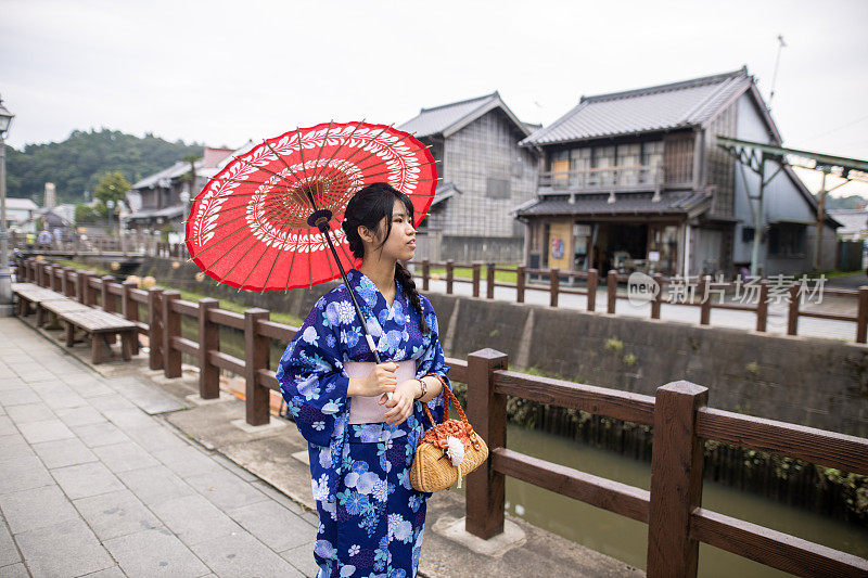 十几岁的女孩在浴田参观一个古老的日本村庄