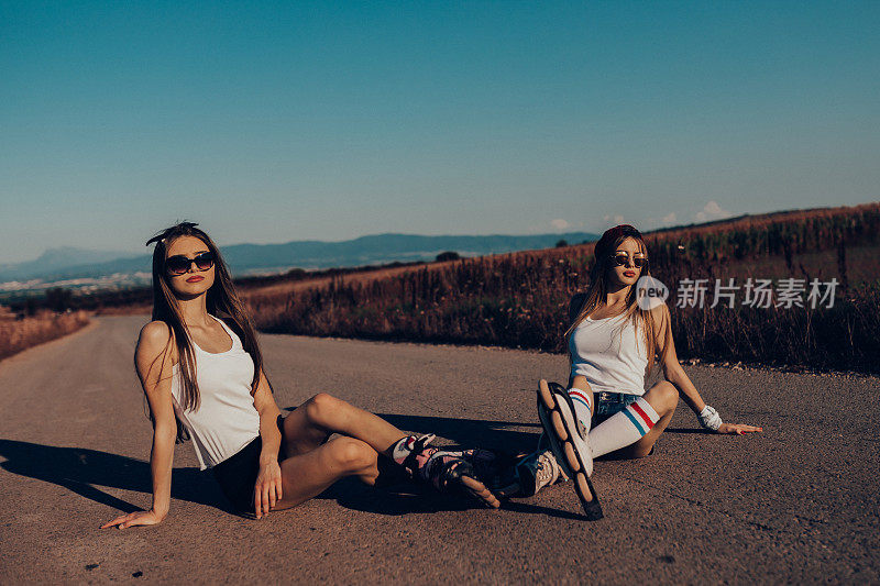 两个十几岁的女孩在一个阳光明媚的夏日驾驶直排轮滑
