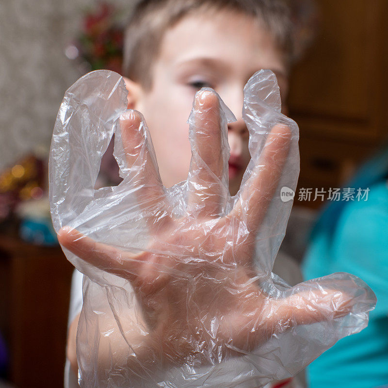 男孩露出一只戴着透明手套的手。有选择性的重点