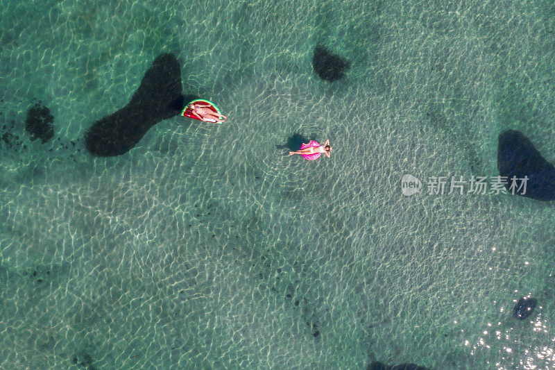 鸟瞰图的妇女漂浮在湖上与充气筏