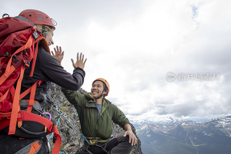 登山者朋友在山脊上击掌