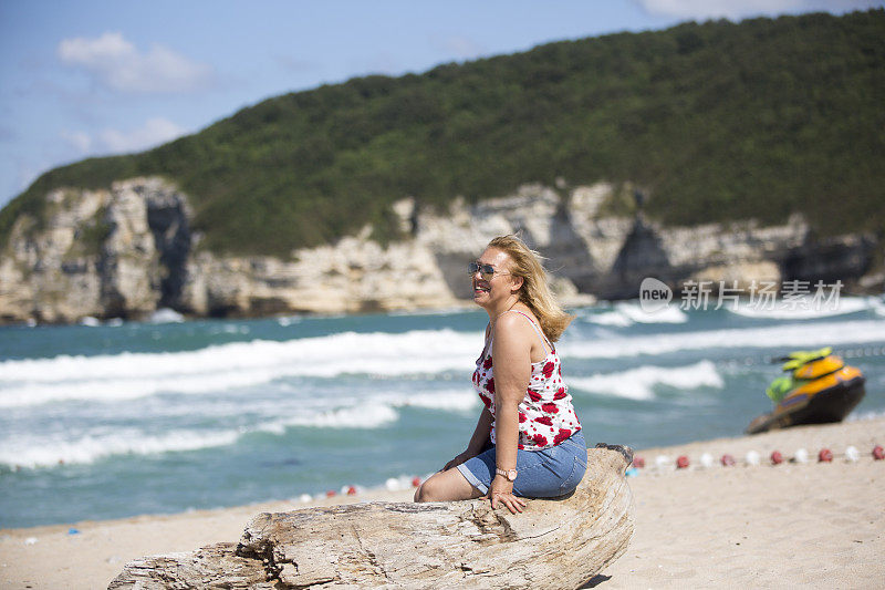 戴着草帽的女人在海滩上散步