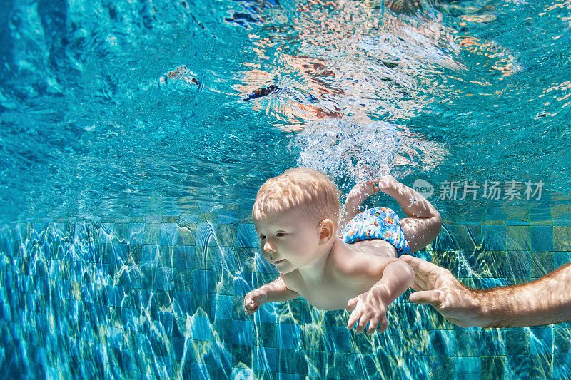 快乐的家庭潜水与乐趣在游泳池