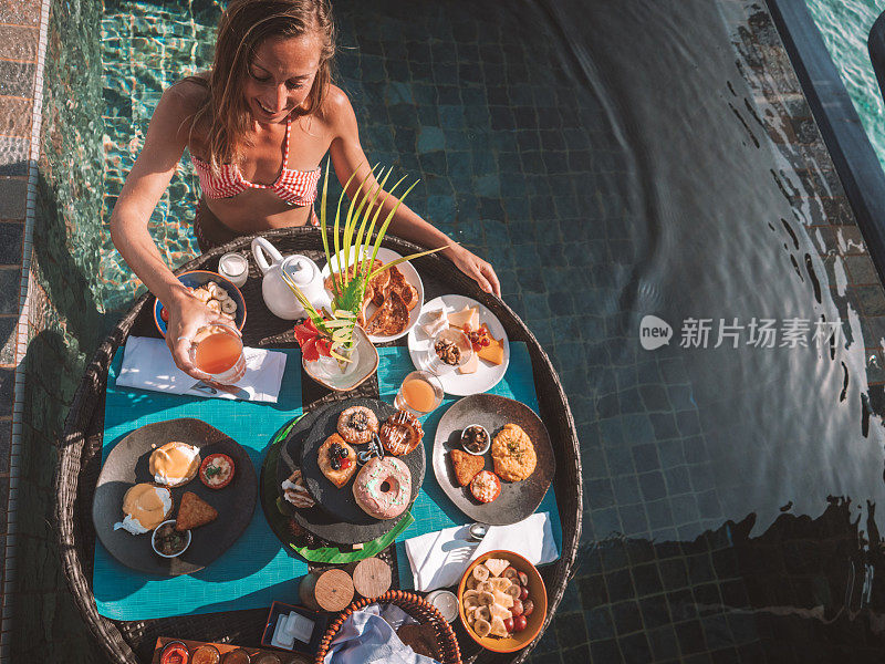 在豪华酒店享受漂浮早餐的女人