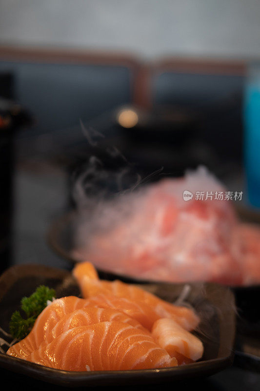 三文鱼生鱼片。黑色的餐桌上放着日本传统菜肴。近距离