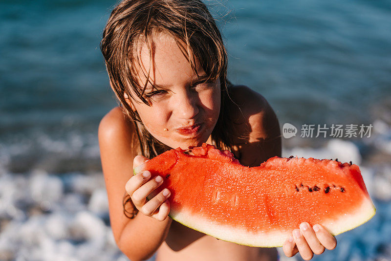 在海滩上吃西瓜的女孩