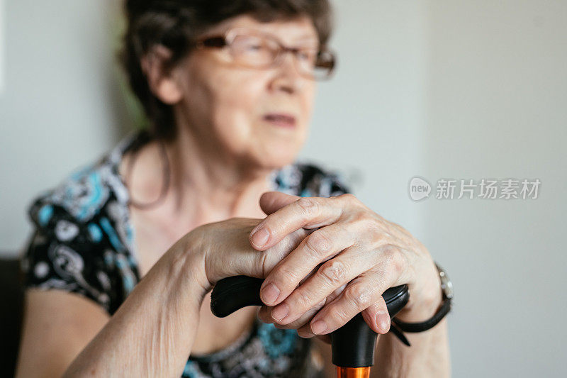 老年妇女在家里拄拐杖的肖像