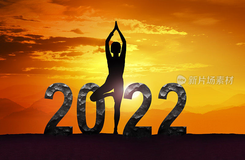 和日落时做瑜伽的女人祝2022年新年快乐