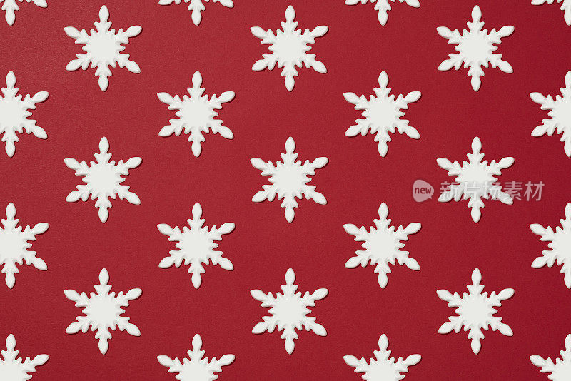 白色的雪花圣诞装饰平放在红色的背景上