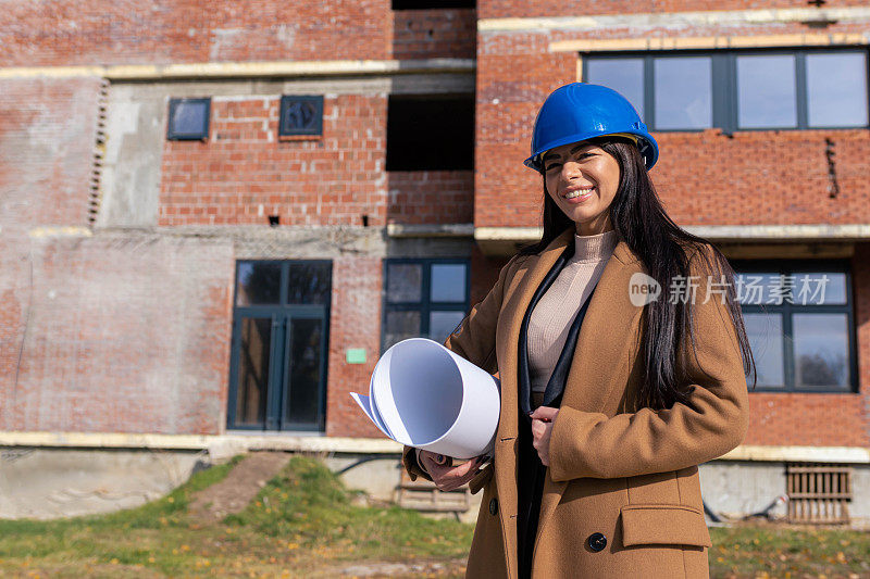 迷人和快乐的女建筑师在工地上