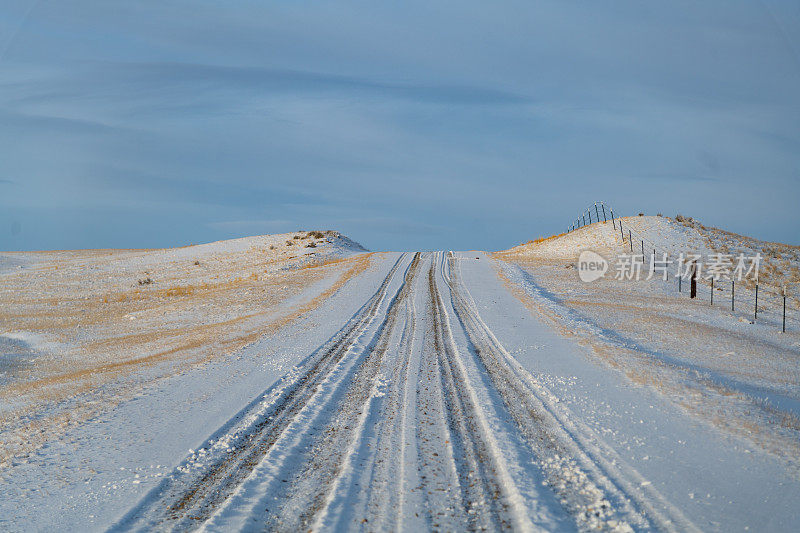 日落时分，蒙大拿山上的泥土路被白雪覆盖