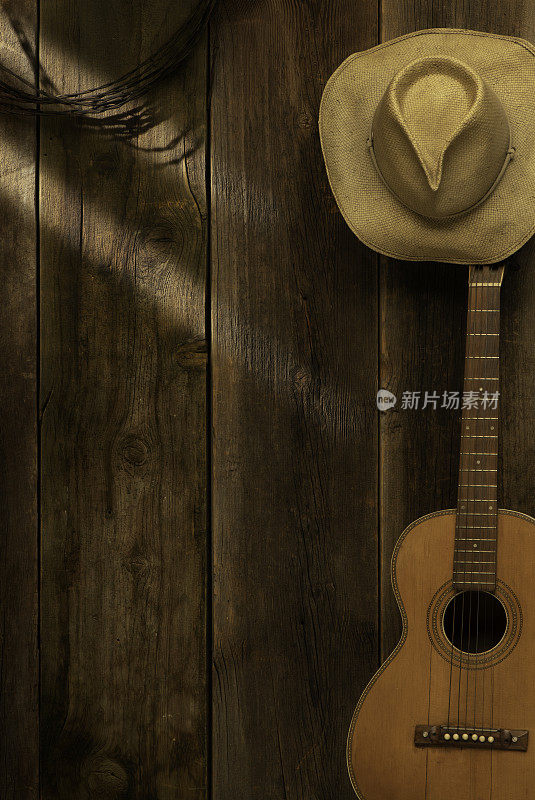 谷仓木材背景与吉他和牛仔帽