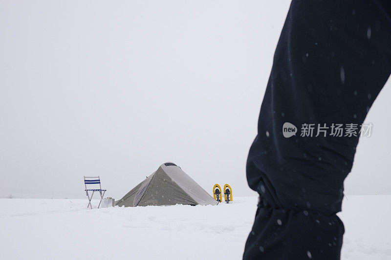 成熟的旅游帐篷露营在冬季的山脉单独在大自然中。