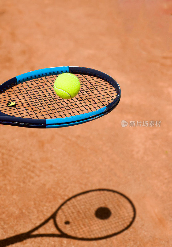 有黄色网球的网球拍头。球拍在地上的影子。球拍的弦。拉伸。复制文本空间。体育主题。背景。