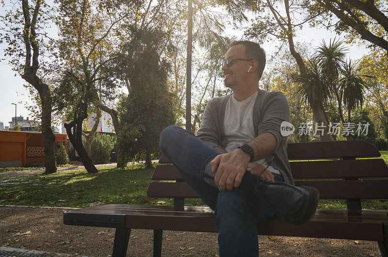 一名男子坐在公园的长椅上放松