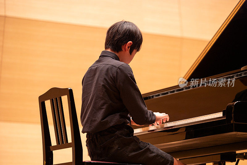 日本男孩在音乐厅弹钢琴
