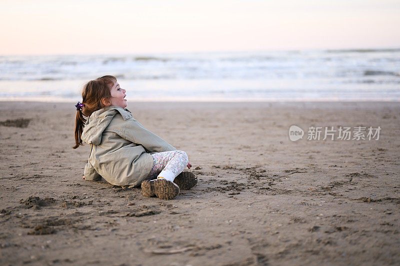 小孩子在寒冷的天气里在海边享受假期。