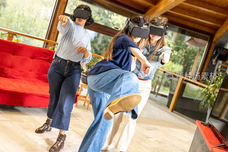 三位年轻女性在家里的客厅里享受虚拟现实，朋友们用新技术玩游戏，戴着增强现实的耳机模拟武术动作