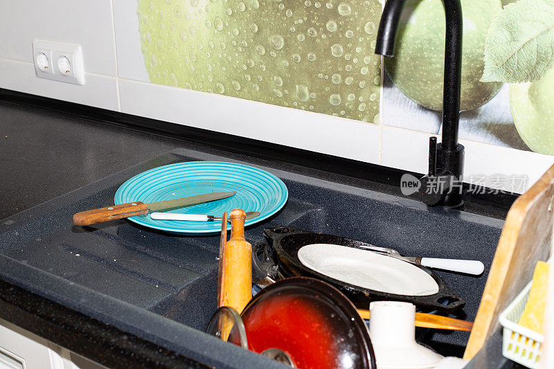厨房水槽里堆满了脏盘子。概念清洁的房子