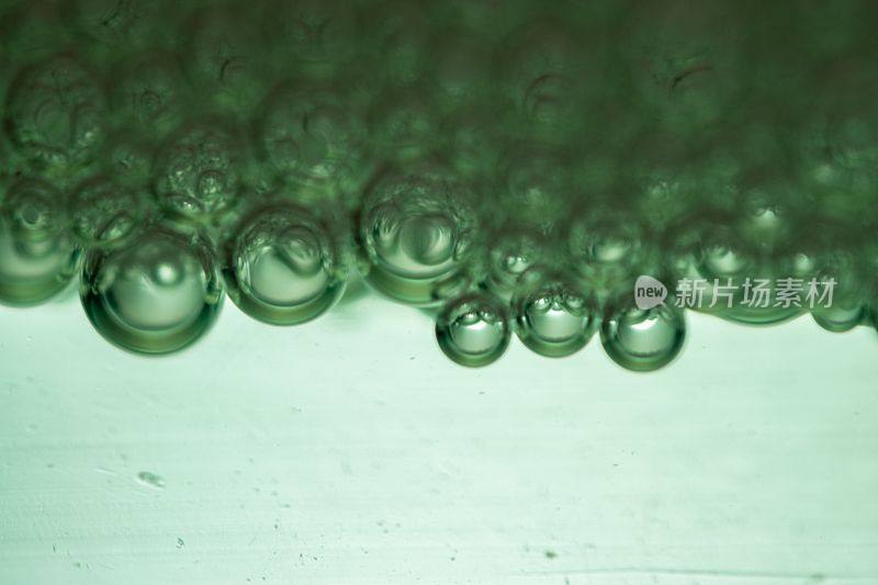 光滑的淡绿色背景与大量的肥皂泡，创造一个梦幻的效果