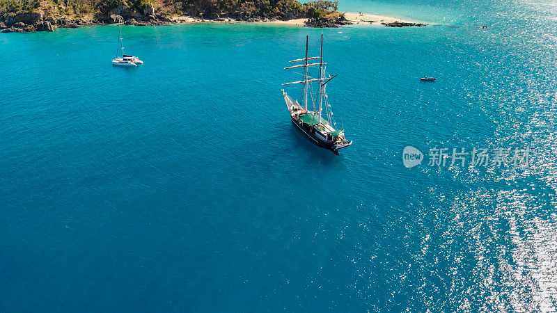 帆船靠近海岸线的一个美丽的热带岛屿，鸟瞰
