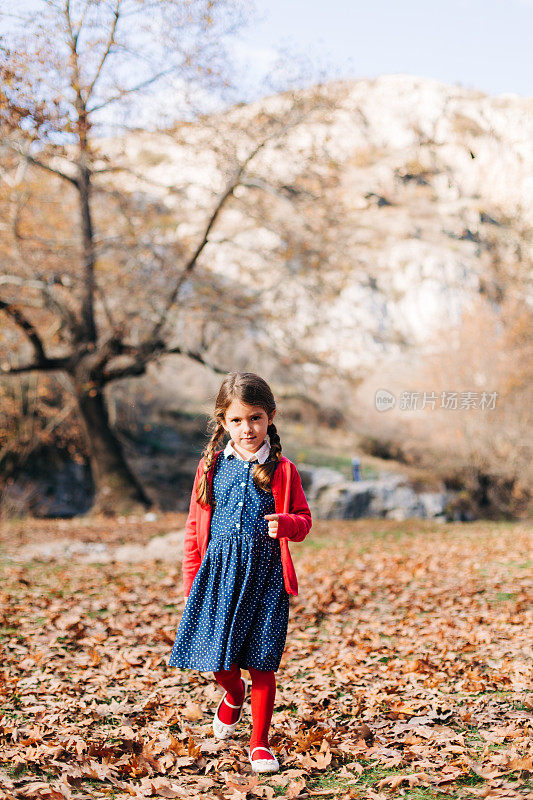小女孩赤脚走在秋天的森林里