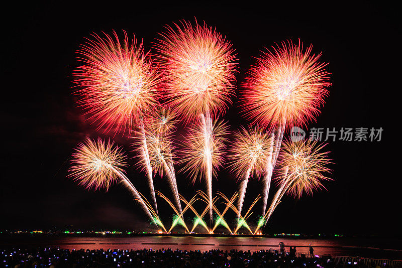 芭堤雅，春武里，泰国，11月-美丽的灯光在晚上，五颜六色的烟花，在芭堤雅国际烟花节和剪影人群的游客