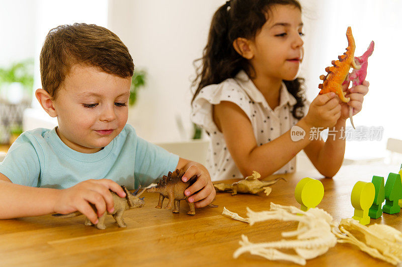孩子们在厨房岛上玩恐龙玩具玩得很开心
