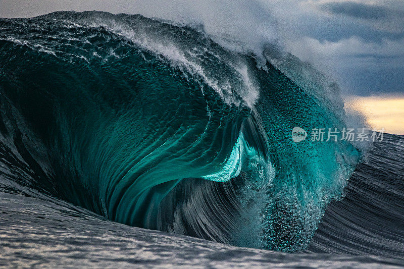 强大的海浪在暴风雨的天空中冲破浅礁的特写