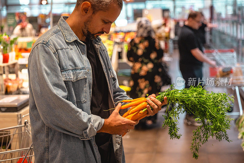 在市场买菜的年轻人-库存照片